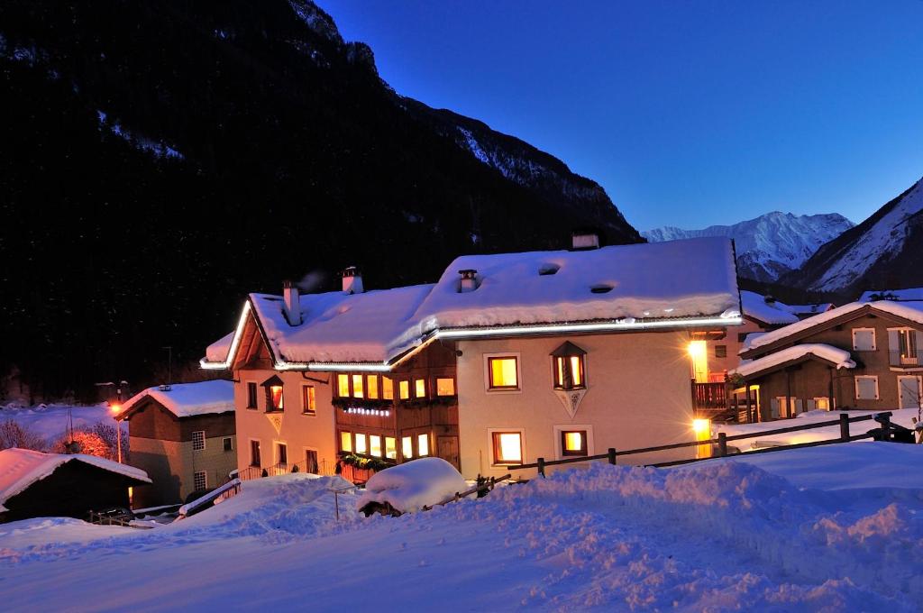 a large building in the snow at night at Chalet La Rugiada in Valdisotto