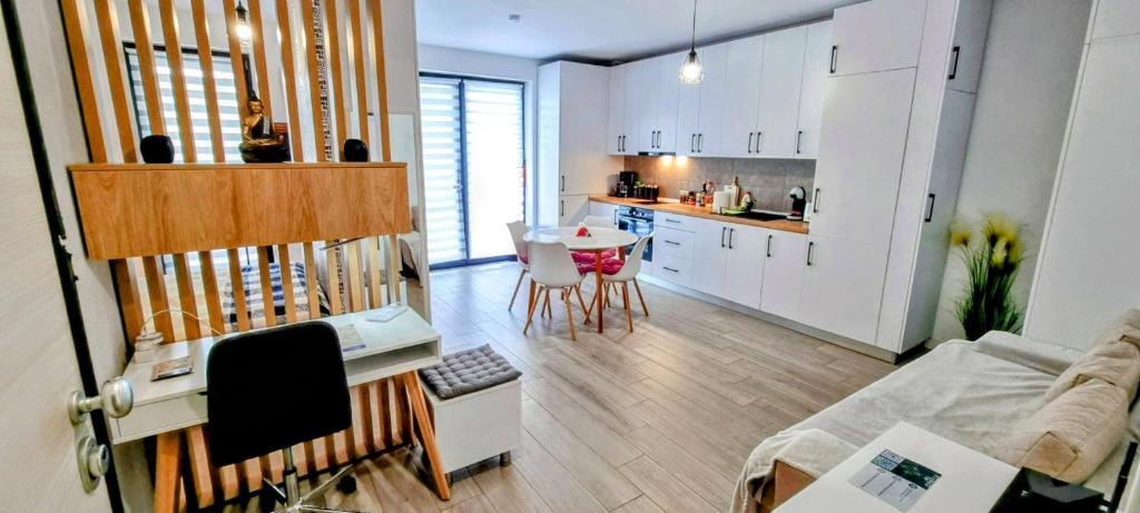 a kitchen and a living room with a couch and a table at ATENEO - Studio DeLuxe MODERN Apartment, BIG Balcony, Plus FREE Parking in Timişoara