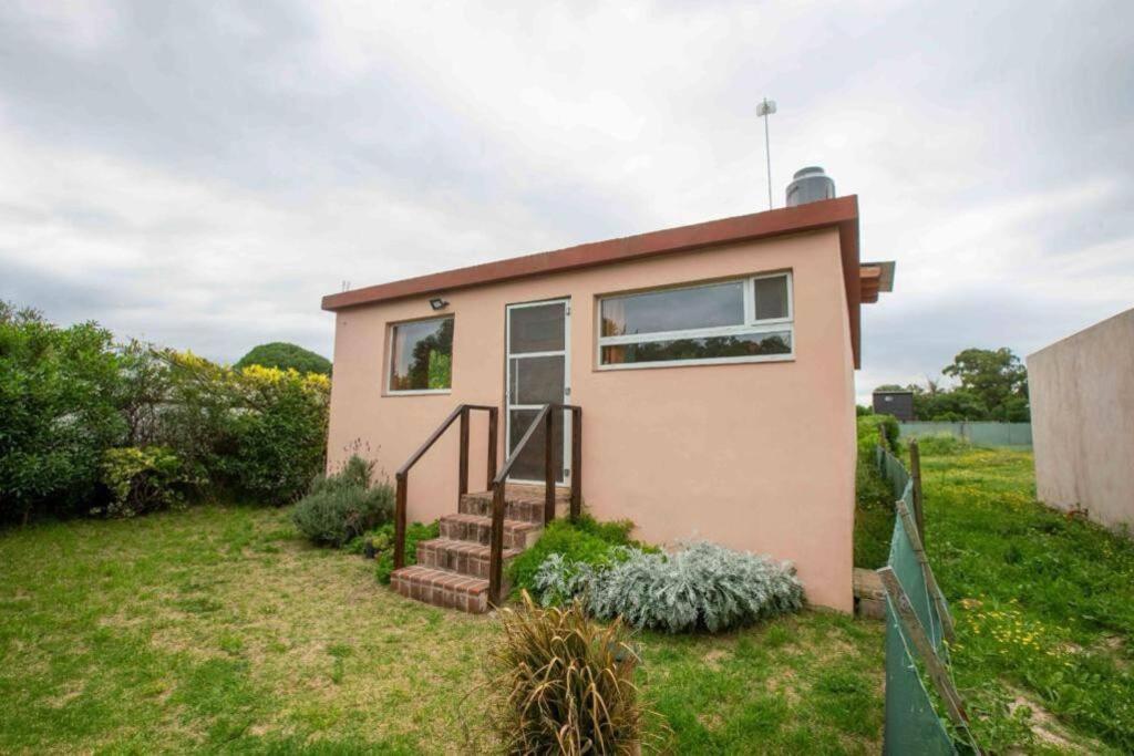 a small house with a staircase in a yard at Casa, Bosque y Mar in Miramar