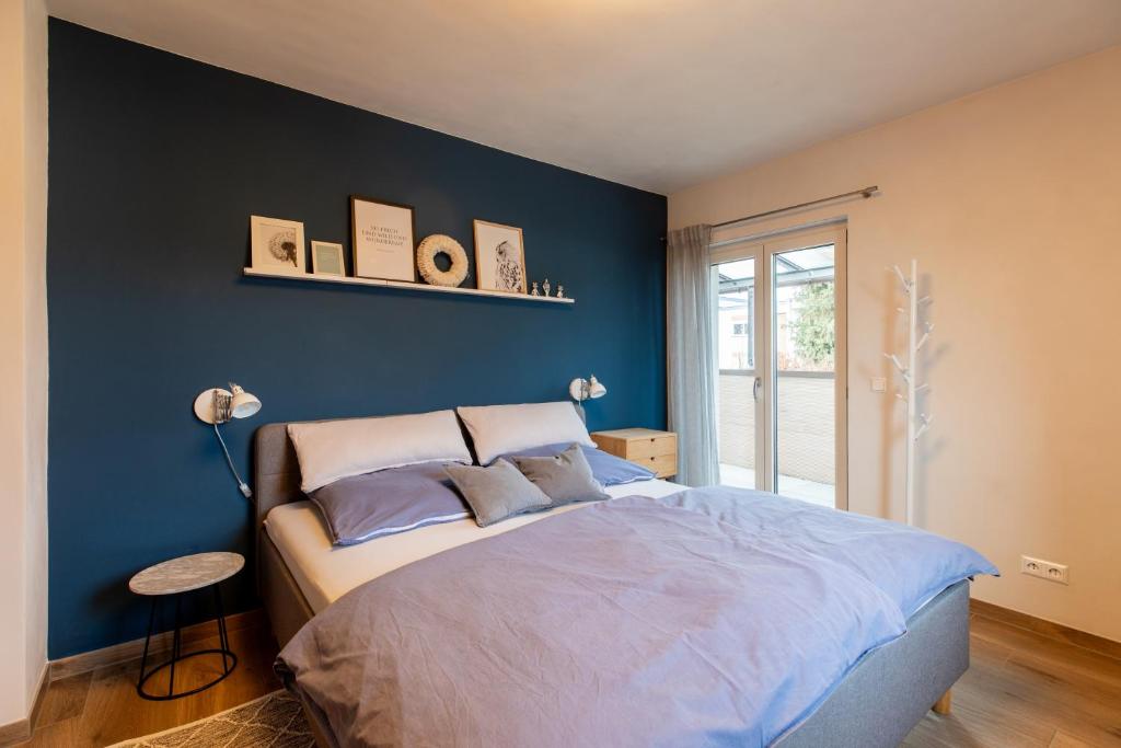 a bedroom with a bed with a blue wall at Laura‘s Heimat in Bad Bergzabern