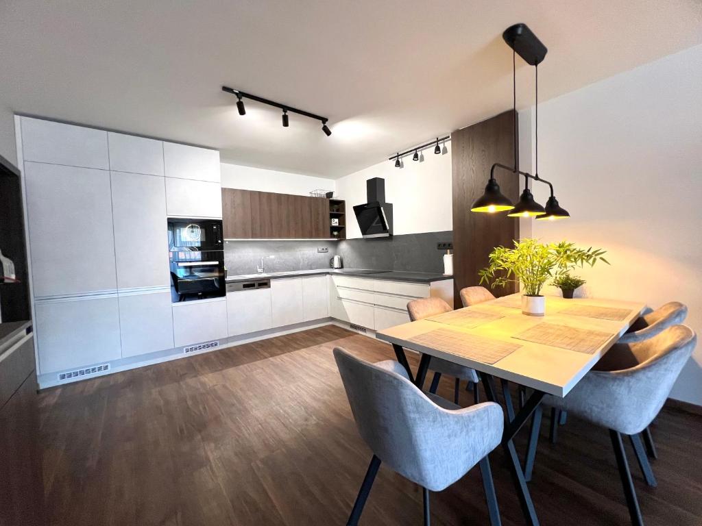 a kitchen and dining room with a table and chairs at Apartmán Manhattan s terasou v centre mesta in Trenčín