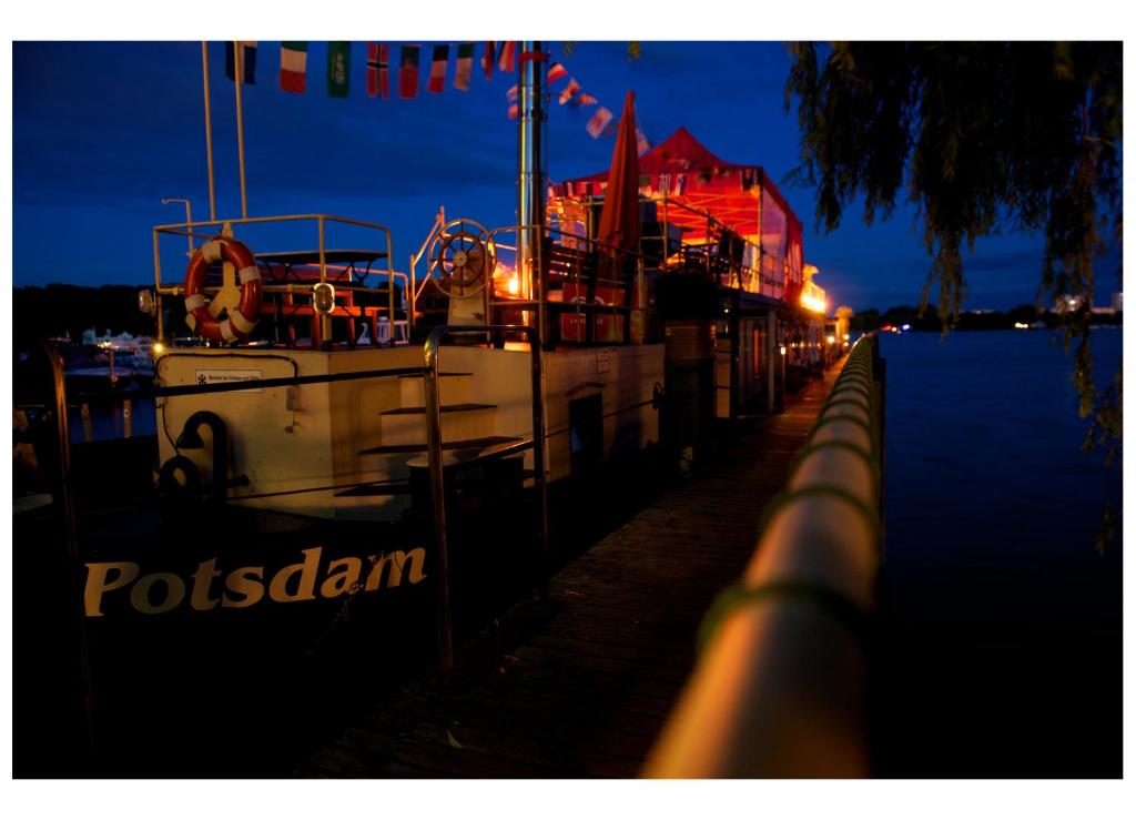 a boat is docked at a dock at night at Schiffspension Luise in Potsdam