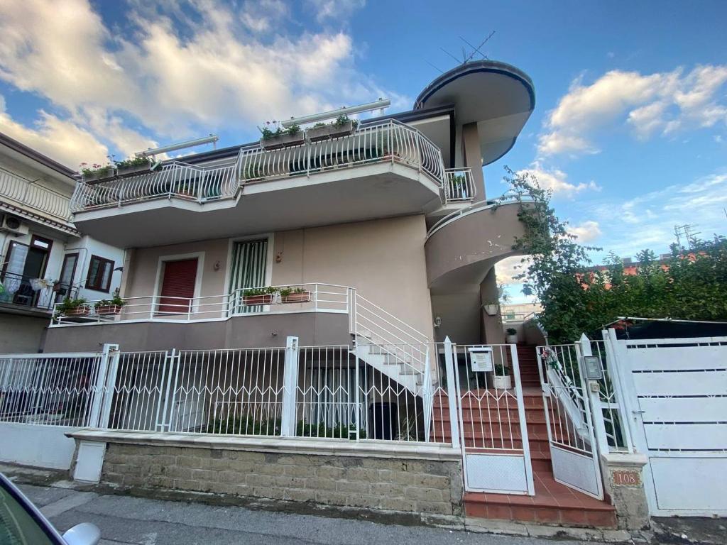 a house with a white fence in front of it at La Bouganville House in Naples