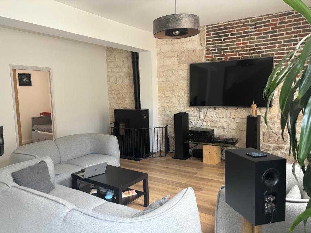 un salon avec deux canapés et une télévision à écran plat dans l'établissement Maison de ville impériale, à Compiègne