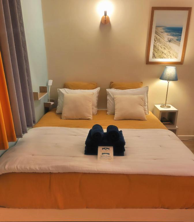 une chambre d'hôtel avec deux lits avec des serviettes sur le lit dans l'établissement Le Coquet, à Saint-Omer