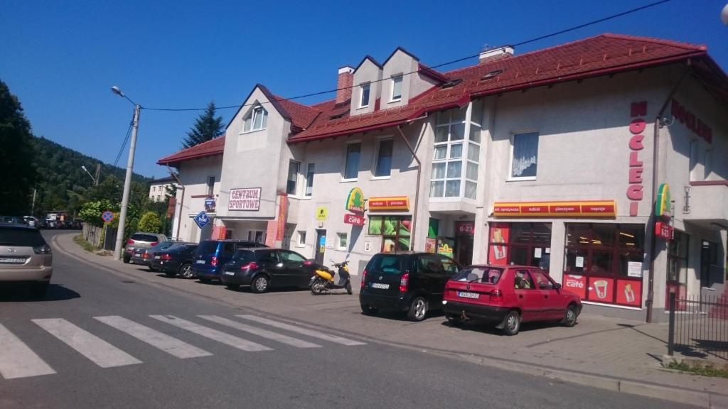 a street with cars parked in front of buildings at Noclegi Helvet in Ustrzyki Dolne