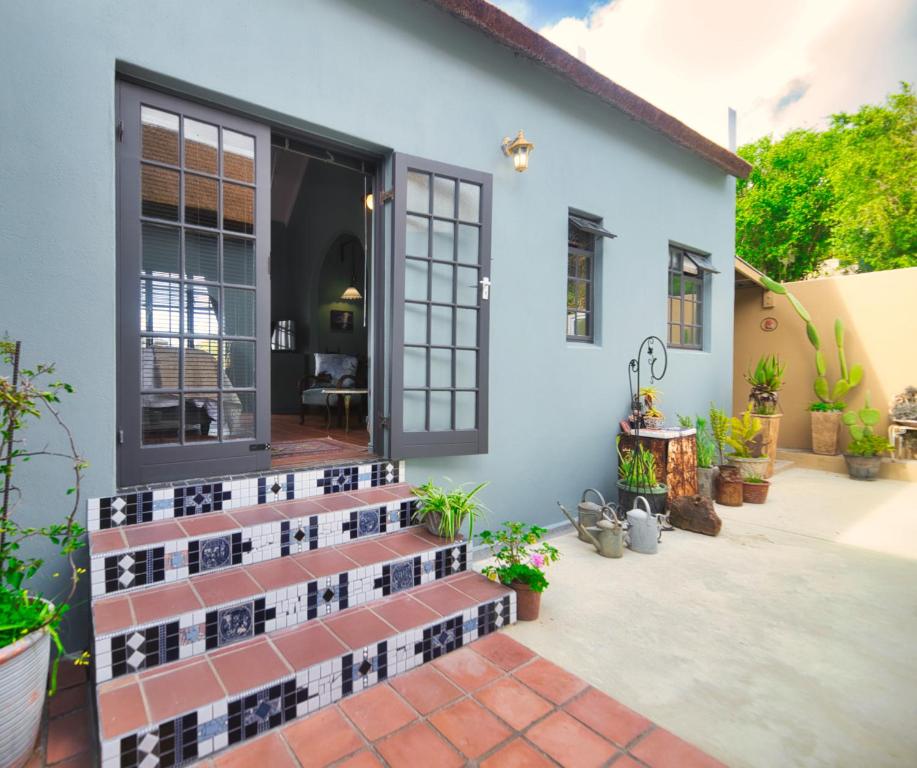 a house with a tile pathway leading to the front door at Grace Courtyard Cottage in Bredasdorp