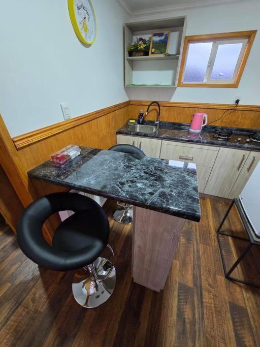 a kitchen with a counter and a black counter top at La Verdecita in Punta Arenas