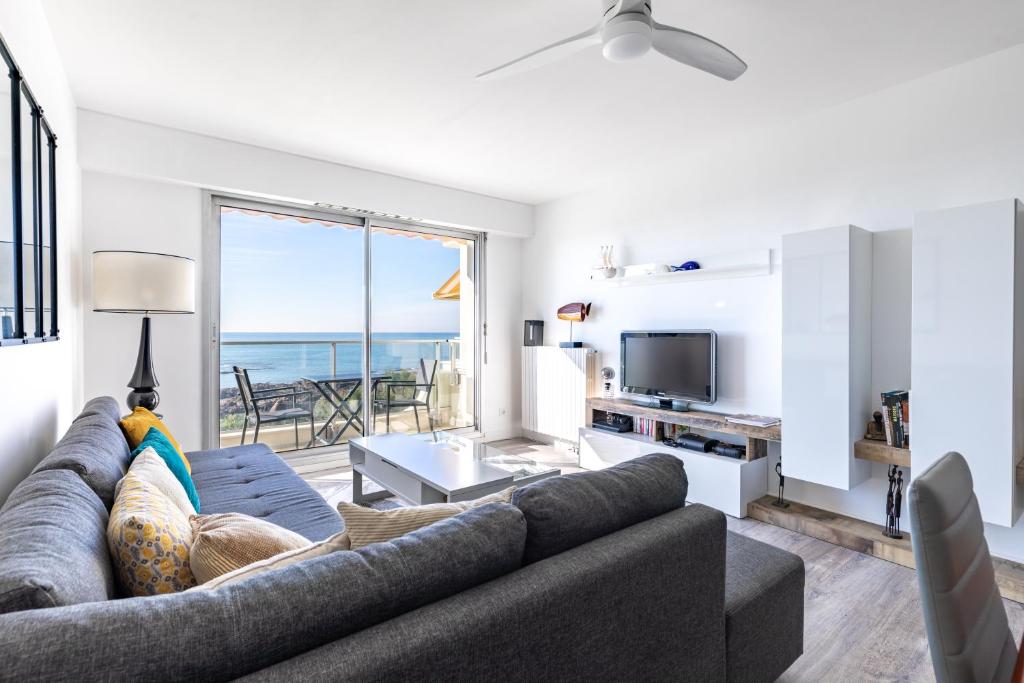 un salon avec un canapé et une vue sur l'océan dans l'établissement Appartement d'exception avec vue plongeante sur l'Océan - Elégance et évasion, à Les Sables-dʼOlonne