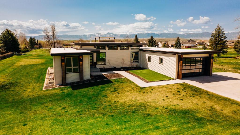 a small house on a field with a grass yard at Contemporary Wyoming Luxury in Sheridan