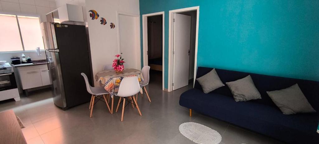 a living room with a blue couch and a table and chairs at Cantinho do descanso in Bertioga