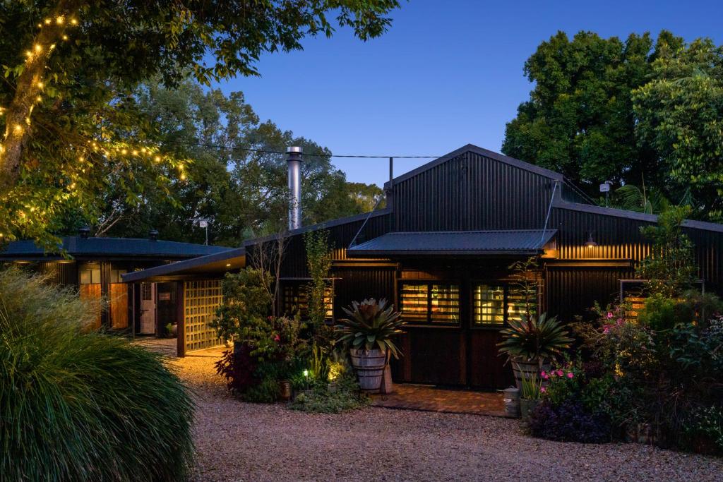 a house with lights on the front of it at The Bangalow Barn in Bangalow
