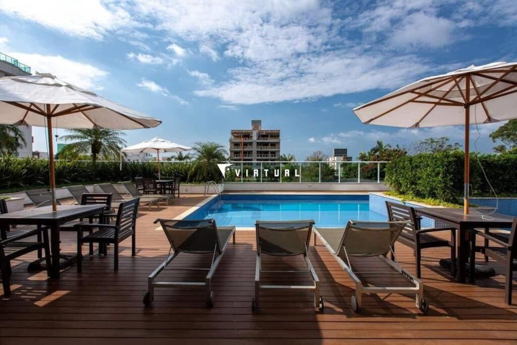 a patio with tables and umbrellas and a pool at o MELHOR DA PRAIA BRAVA !!! in Itajaí