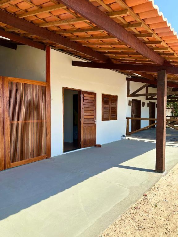 a patio of a house with a wooden pergola at Casa do Pescador - Praia do Maceió - Camocim - CE in Camocim