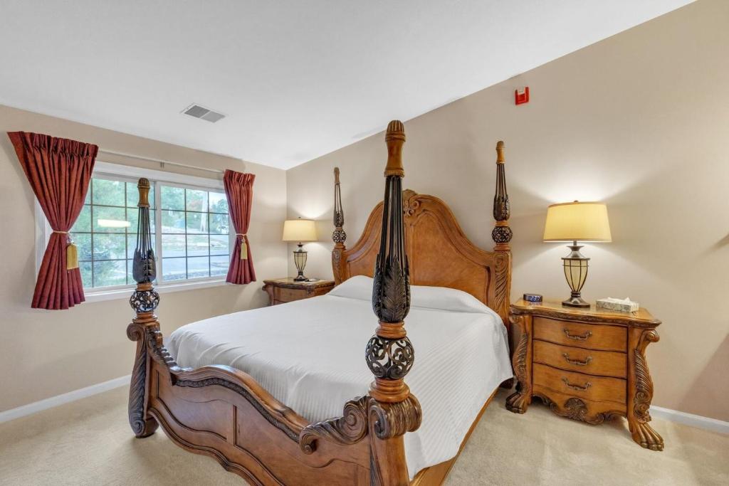 a bedroom with a wooden bed and a dresser and lamps at Grand Wood Suites - 3rd Floor Back Side Penthouse Suite 306 in Nashville