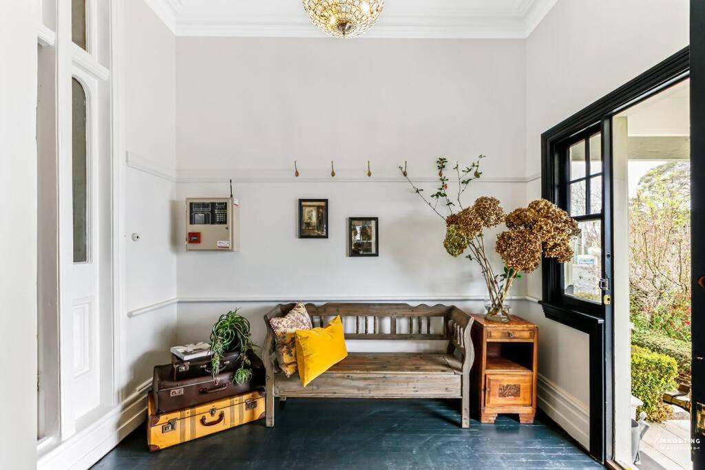 a living room with a bench and a table at Norwood Arthouse 7 Bedroom 7 Bathroom in Blackheath