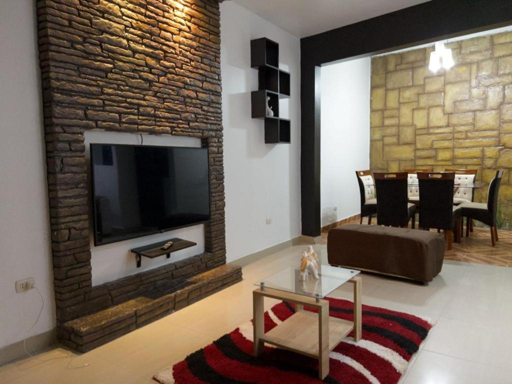 塔拉波托Descanso tropical 1的客厅设有砖墙和电视