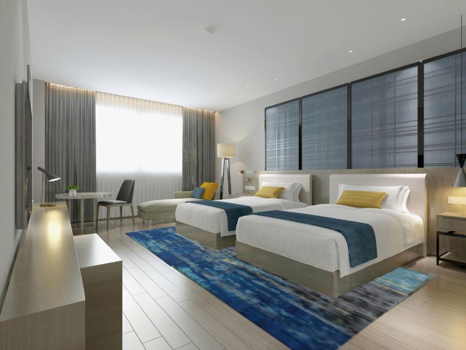 una camera da letto con 2 letti e una scrivania di Echarm Hotel Changsha Foreign Economics Institute Branch a Leifeng