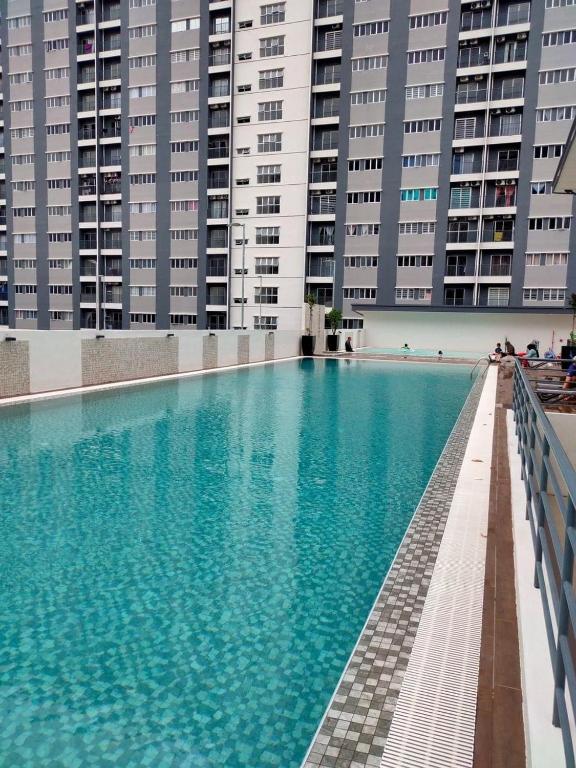 una grande piscina in un edificio con edifici alti di SYG9 Kita Impian Cybersouth Homestay 3 Bilik Tidur with Swimming Pool a Kampung Dengkil