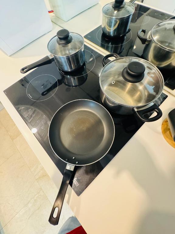 a stove with pots and pans on top of it at Vortex Suites Klcc 2bedroom & 3bedroom apartment in Kuala Lumpur