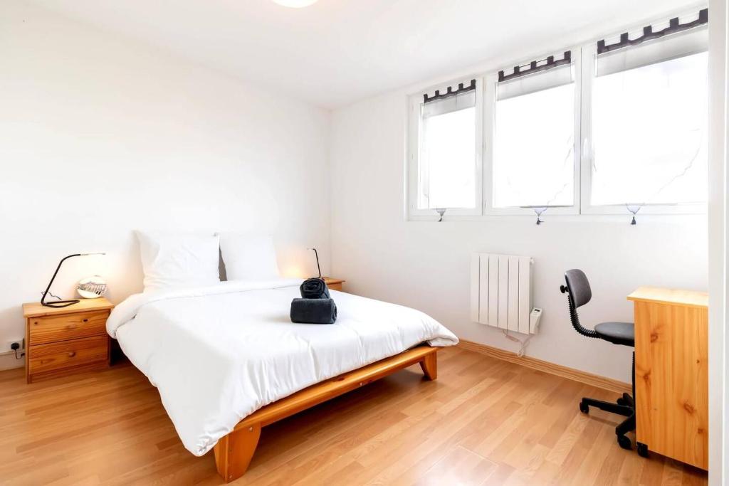 une chambre avec un lit et un bureau et deux fenêtres dans l'établissement Appartement 3 chambre 74m2, à Mulhouse