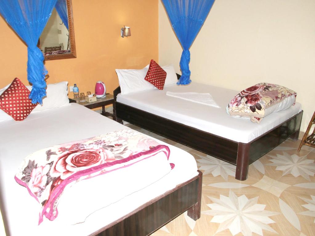 Postel nebo postele na pokoji v ubytování Hotel Rhino Land-Sauraha Family Home