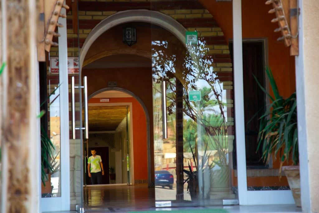 a man standing in an archway of a building at Résidence El Arich in Tozeur