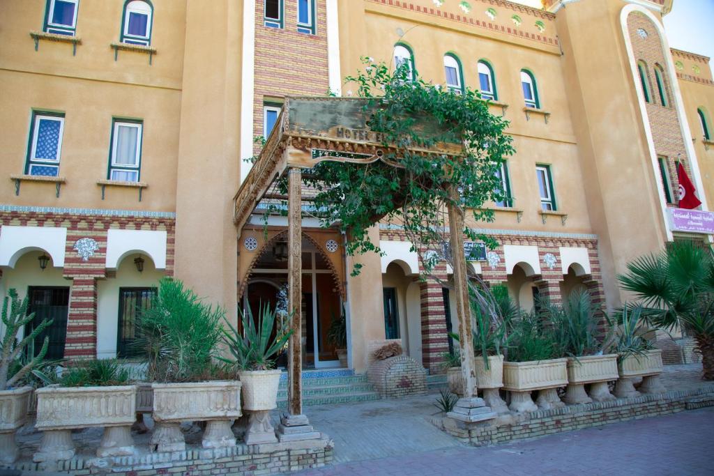 a building with an arch in front of it at Résidence El Arich in Tozeur