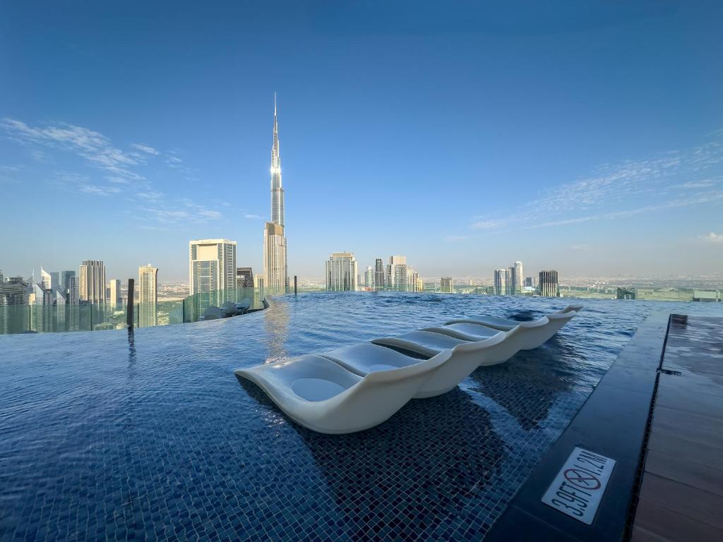 a row of toilets in the water with a city skyline at 64th floor Skyline Pool with Burj Khalifa View in Paramount Hotel Midtown in Dubai