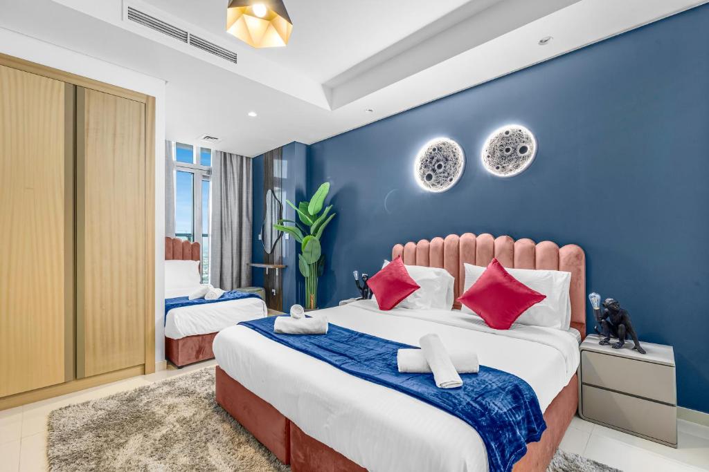 a bedroom with two beds and a blue wall at 64th floor Skyline Pool with Burj Khalifa View in Paramount Hotel Midtown in Dubai