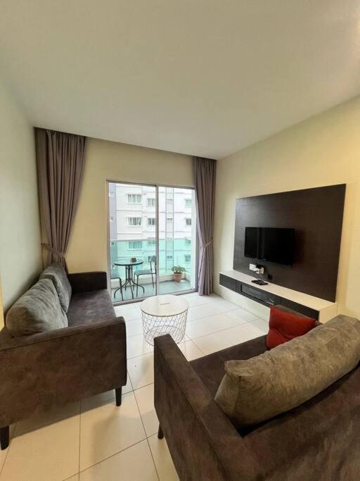 a living room with two couches and a flat screen tv at Lily Brava 5 in Tanah Rata
