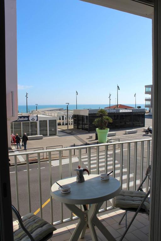 - une table sur un balcon avec vue sur la rue dans l'établissement Charmant studio climatisé proche plage et animations - 3HYPO10, à Saint Cyprien Plage