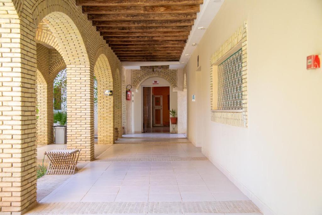 an empty hallway of a building with arches at Résidence El Arich in Tozeur
