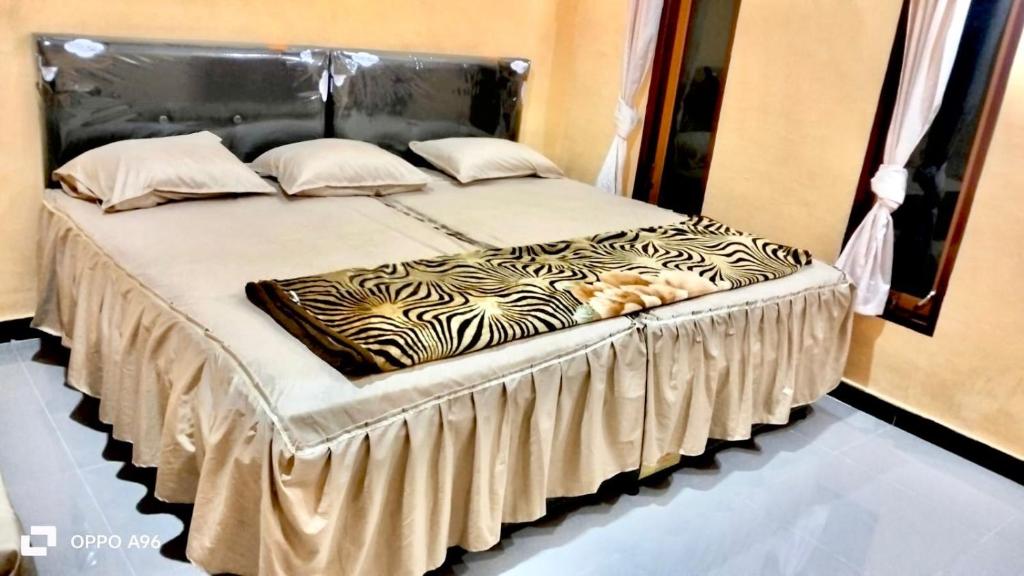 Postel nebo postele na pokoji v ubytování UNIQDO Inn Tomok