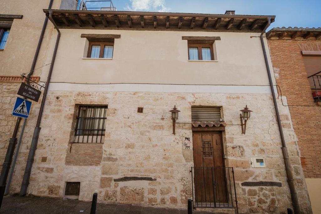 an old stone building with a wooden door at El Desvan Del Brigante in Lerma