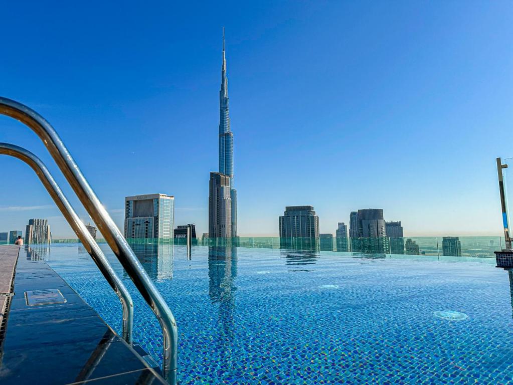 a swimming pool with a view of the burj skyscraper at 64th floor Skyline Pool with Burj Khalifa View in Paramount Hotel Midtown in Dubai
