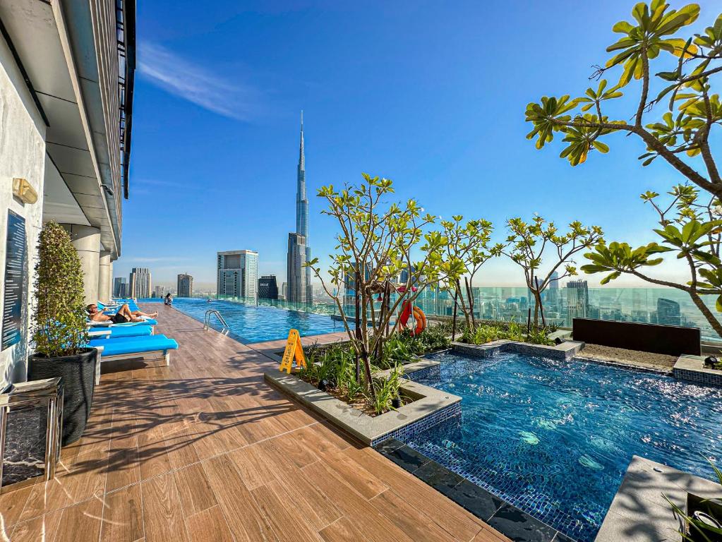 a pool on the top of a building with a view at 64th floor Skyline Pool with Burj Khalifa View in Paramount Hotel Midtown in Dubai