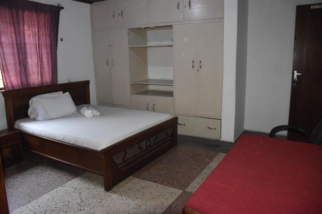 een slaapkamer met een bed en witte kasten bij Kituri Hostel in Dar es Salaam
