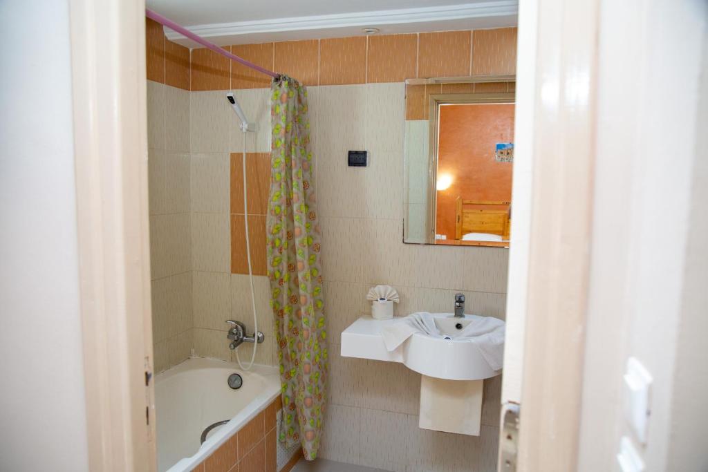 a bathroom with a sink and a bath tub at Résidence El Arich in Tozeur