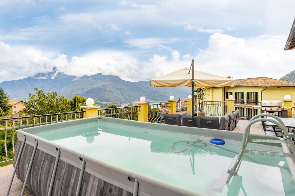 a hot tub on a deck with mountains in the background at Magic Terrace With Lake View in Stazzona