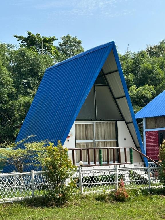 una casa con un techo azul encima en TULDA BAMBUSA RESORT, en Kāziranga