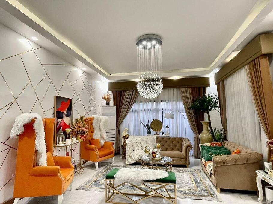a living room with orange furniture and a chandelier at Breeyana's Private Resort in Biñan