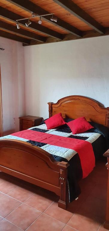 a bedroom with a wooden bed with red pillows at Club JM Lanzarote in Tabayesco