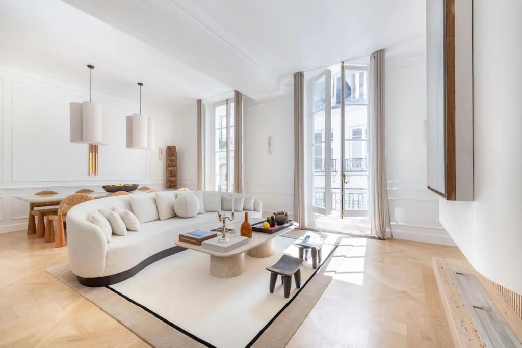 un salon avec un canapé blanc et une table dans l'établissement Appartement de luxe Marais, à Paris
