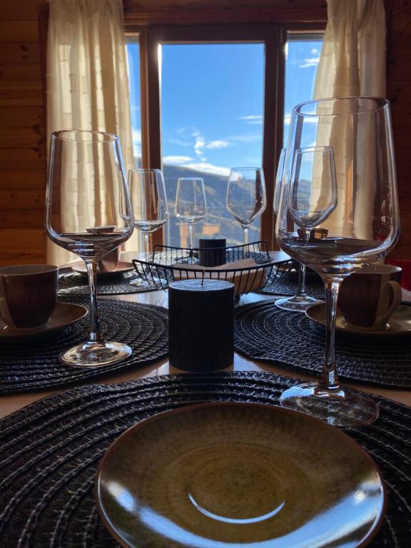 a table with wine glasses and a plate on it at Cabaña con encanto y vistas increíbles!! in Sierra Nevada