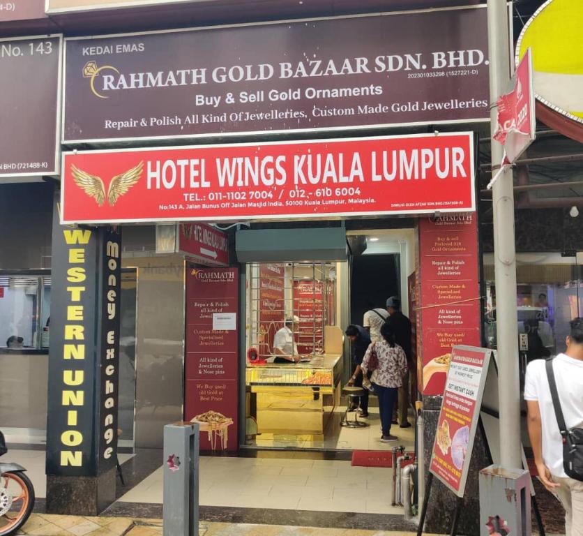 a restaurant with red signs and people standing outside at Hotel Wings Kuala Lumpur in Kuala Lumpur