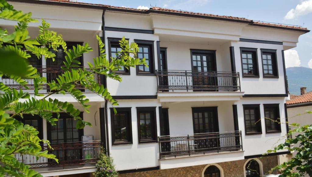 a white building with black windows and balconies at Villa Dudanov in Ohrid