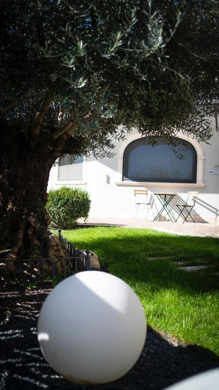 a white object sitting in the grass next to a tree at Casa Catone (affitta camere) in Monte Porzio Catone