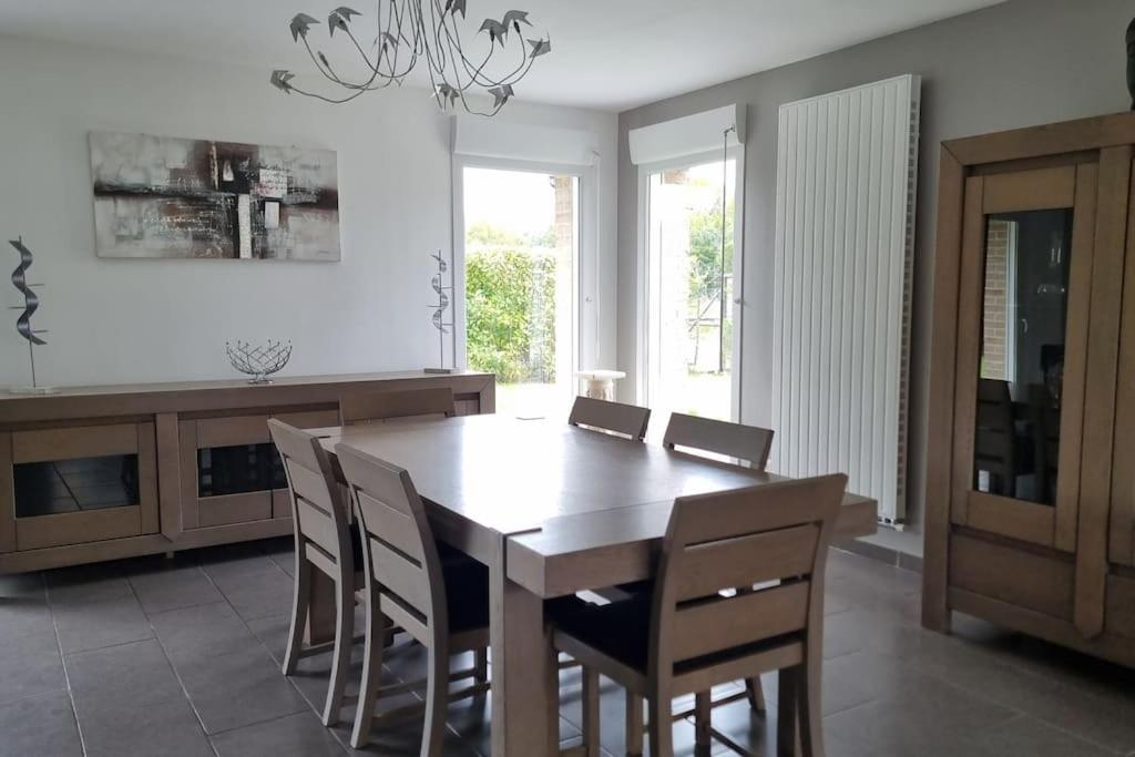 une salle à manger avec une table et des chaises en bois dans l'établissement Maison du Fort Vallières - Bois des forts, à Boomkens