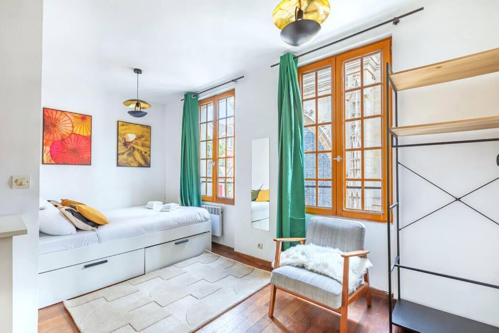 une chambre avec un lit et une chaise dans l'établissement Studio intimiste au cœur du Marais historique, à Paris